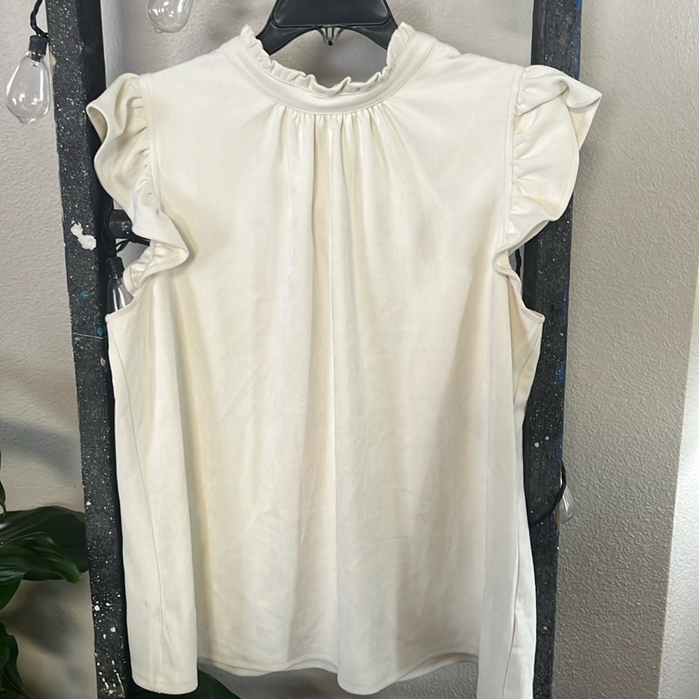 Off white ruffle top. Feels like and looks like velvet. Very good quality made.